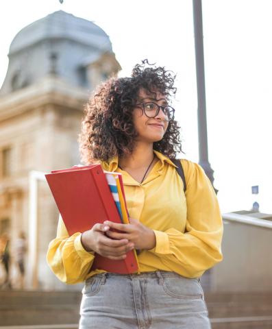 Doctorante avec ses livres à la sortie du cours 